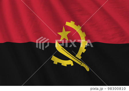 Angola flag with big folds waving close up under the studio light indoors. The official symbols and colors in banner Angola flag with big folds waving close up under the studio light indoors. The official symbols and colors in banner 98300810