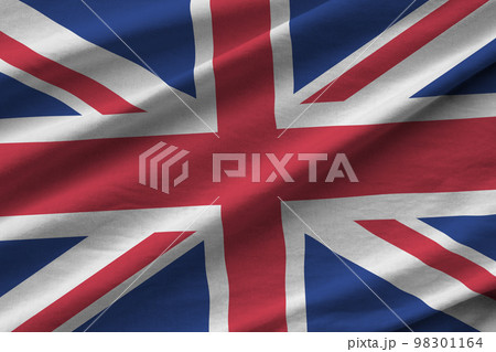 Great britain flag with big folds waving close up under the studio light indoors. The official symbols and colors in banner 98301164