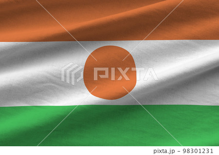 Niger flag with big folds waving close up under the studio light indoors. The official symbols and colors in banner 98301231