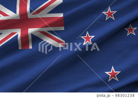 New Zealand flag with big folds waving close up under the studio light indoors. The official symbols and colors in banner 98301238