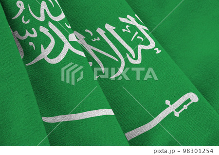 Saudi Arabia flag with big folds waving close up under the studio light indoors. The official symbols and colors in banner Saudi Arabia flag with big folds waving close up under the studio light indoors. The official symbols and colors in banner 98301254