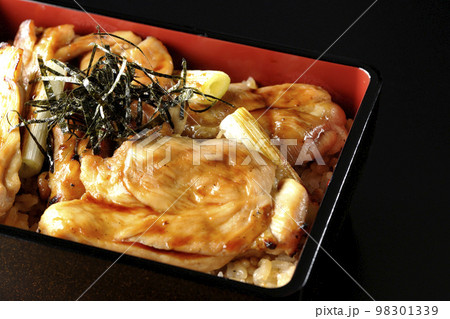 タレがたっぷりかかった焼き長葱と焼き鳥重を黒背景で撮影 98301339