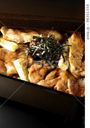タレがたっぷりかかった焼き長葱と焼き鳥重を黒背景で撮影 98301359