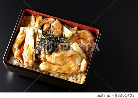 タレがたっぷりかかった焼き長葱と焼き鳥重を黒背景で俯瞰撮影 タレがたっぷりかかった焼き長葱と焼き鳥重を黒背景で俯瞰撮影 98301405