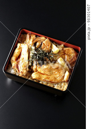 タレがたっぷりかかった焼き長葱と焼き鳥重を黒背景で俯瞰撮影 98301407