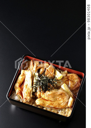 タレがたっぷりかかった焼き長葱と焼き鳥重を黒背景で俯瞰撮影 98301408