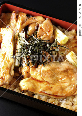 タレがたっぷりかかった焼き長葱と焼き鳥重を黒背景で俯瞰撮影 98301410