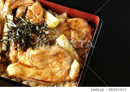 タレがたっぷりかかった焼き長葱と焼き鳥重を黒背景で俯瞰撮影 98301417