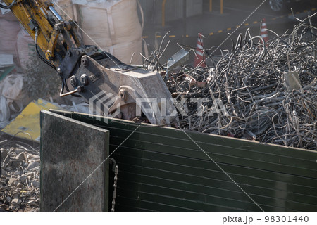 解体工事現場　鉄筋くずを運搬車に積む重機 98301440