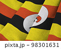 Uganda flag with big folds waving close up under the studio light indoors. The official symbols and colors in banner 98301631