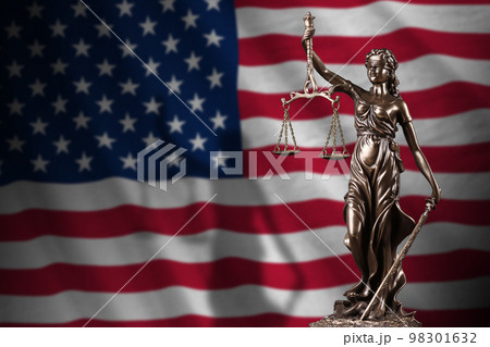 United States of America flag with statue of lady justice and judicial scales in dark room. Concept of judgement and punishment 98301632