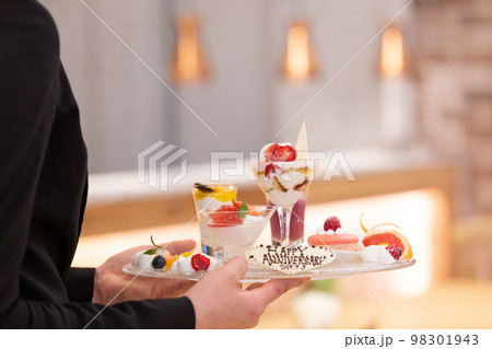 スイーツをサービスする女性が働くカフェのイメージ画像　記念日サプライズ 98301943