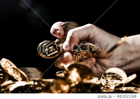 金貨を鷲掴みする男性の手 98302299