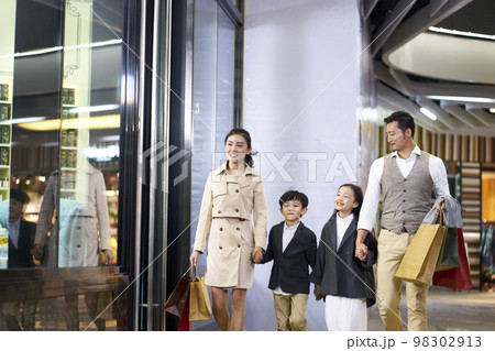 happy asian family with two children walking in shopping mall happy asian family with two children walking in shopping mall 98302913