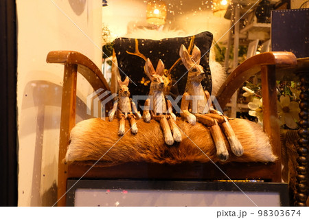 椅子に座る木製のうさぎの置物 98303674