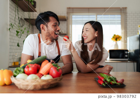 Portrait of young asian couple making salad together at home. cooking food and Lifestyle moment and healthy 98303792