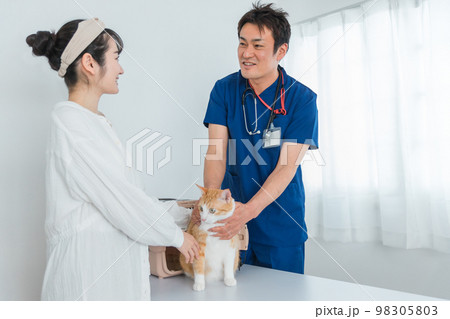 動物病院で獣医師に診察を受ける猫と飼い主のアジア人女性(ペット・相談・診察・診療) 動物病院で獣医師に診察を受ける猫と飼い主のアジア人女性(ペット・相談・診察・診療) 98305803