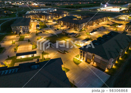 Aerial view from drone of mansions or hotel with beautiful buildings, view of the night city with residential houses and parking. Aerial view from drone of mansions or hotel with beautiful buildings, view of the night city with residential houses and parking. 98306868