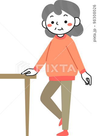 机につかまって片足立ちの運動をするシニア女性 98308026