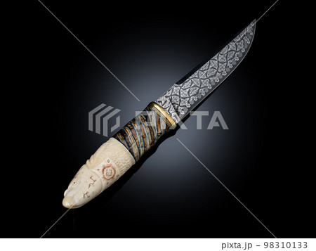 souvenir collectible silver gold dagger cutlass with scabbard, with metal engraving, Bone handle on black. Luxury weapons with traditional patterns in medieval vintage viking shamanic style souvenir collectible silver gold dagger cutlass with scabbard, with metal engraving, Bone handle on black. Luxury weapons with traditional patterns in medieval vintage viking shamanic style 98310133