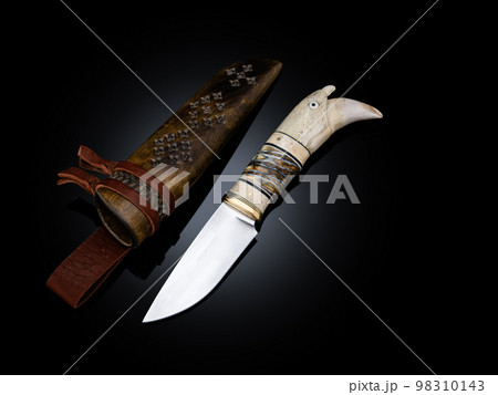 souvenir collectible silver gold dagger cutlass with scabbard, with metal engraving, Bone handle on black. Luxury weapons with traditional patterns in medieval vintage viking shamanic style souvenir collectible silver gold dagger cutlass with scabbard, with metal engraving, Bone handle on black. Luxury weapons with traditional patterns in medieval vintage viking shamanic style 98310143