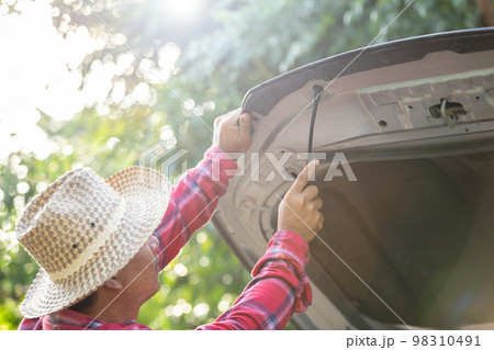 Man opening and set up front car bonnet to checking up the engine. Car maintenance Man opening and set up front car bonnet to checking up the engine. Car maintenance 98310491