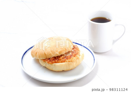 オーストリア発祥のロールパンのカイザーゼンメルにハムカツを挟んだサンドイッチとコーヒーの軽食をとる オーストリア発祥のロールパンのカイザーゼンメルにハムカツを挟んだサンドイッチとコーヒーの軽食をとる 98311124