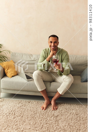 Happy Man Drinking Wine At Home. Smiling Handsome Guy Relaxing On Sofa Happy Man Drinking Wine At Home. Smiling Handsome Guy Relaxing On Sofa 98311410
