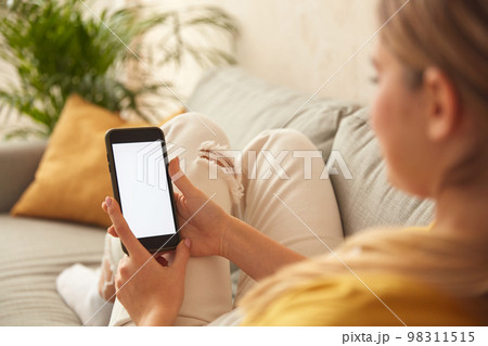 Woman Using Smartphone At Home. Blonde Girl Sitting On Sofa And Messaging 98311515