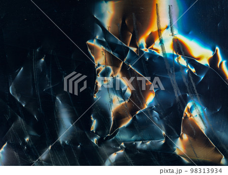 Scratched film texture. Crumpled noise. Distressed foil surface. Orange blue white color glow dust stains on dark black grunge abstract background. 98313934