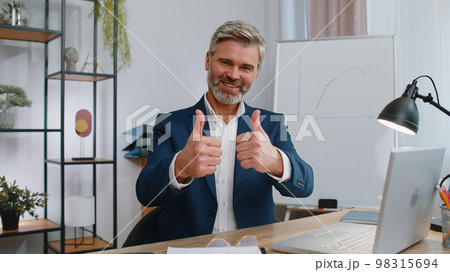 Happy business man looking approvingly at camera showing thumbs up, like positive sign, good news 98315694