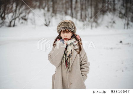 雪の積もった冬景色の中で無邪気に楽しむ女性 98316647