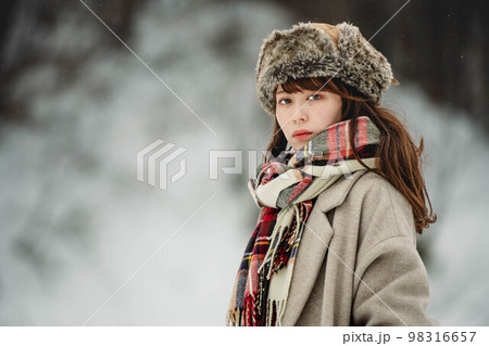 雪の積もった冬景色の中で無邪気に楽しむ女性 98316657