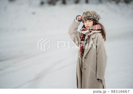 雪の積もった冬景色の中で無邪気に楽しむ女性 98316667