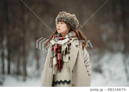 雪の積もった冬景色の中で無邪気に楽しむ女性 98316674
