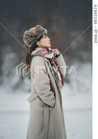雪の積もった冬景色の中で無邪気に楽しむ女性 98316679