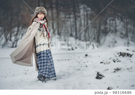 雪の積もった冬景色の中で無邪気に楽しむ女性 98316686