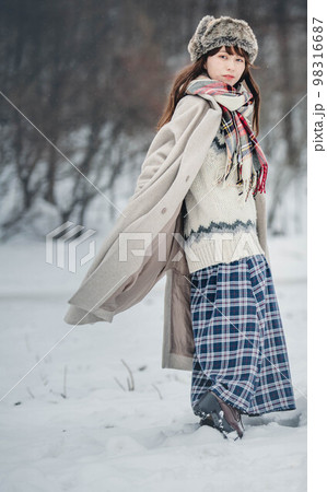 雪の積もった冬景色の中で無邪気に楽しむ女性 98316687