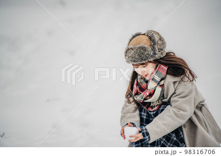 雪山で雪玉を作って楽しむ女性 雪山で雪玉を作って楽しむ女性 98316706