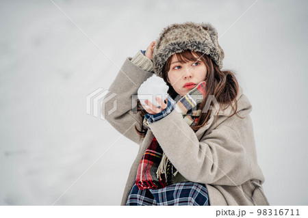 雪山で雪玉を作って楽しむ女性 98316711