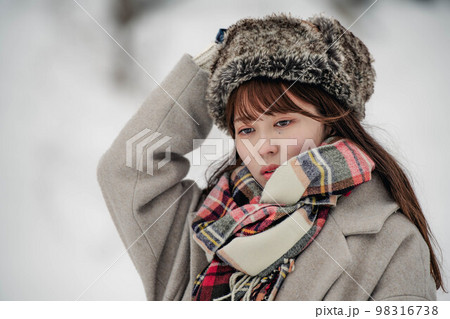 雪の積もった冬景色の中で無邪気に楽しむ女性 98316738