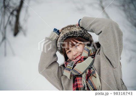 雪の積もった冬景色の中で無邪気に楽しむ女性 98316743