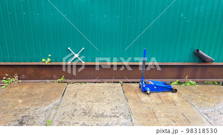 Auto repair shop tire repair tools are lying near the green fence Auto repair shop tire repair tools are lying near the green fence 98318530
