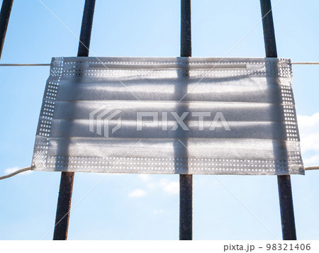 Medical face mask on an iron grill. Medical face mask on an iron grill. 98321406