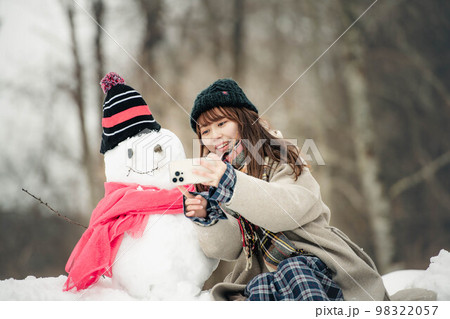 雪だるまを作って遊ぶ女性 98322057
