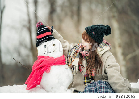 雪だるまを作って遊ぶ女性 98322065