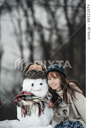 雪だるまを作って遊ぶ女性 雪だるまを作って遊ぶ女性 98322074