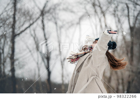 雪山で雪を投げて遊ぶ女性 雪山で雪を投げて遊ぶ女性 98322266