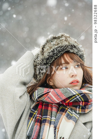 楽しそうに雪が降る様子を眺める女性 98322688