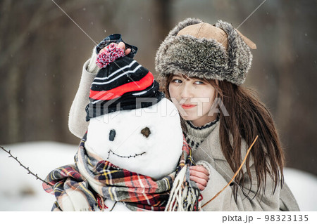 雪だるまを作り楽しそうにしている女性 98323135
